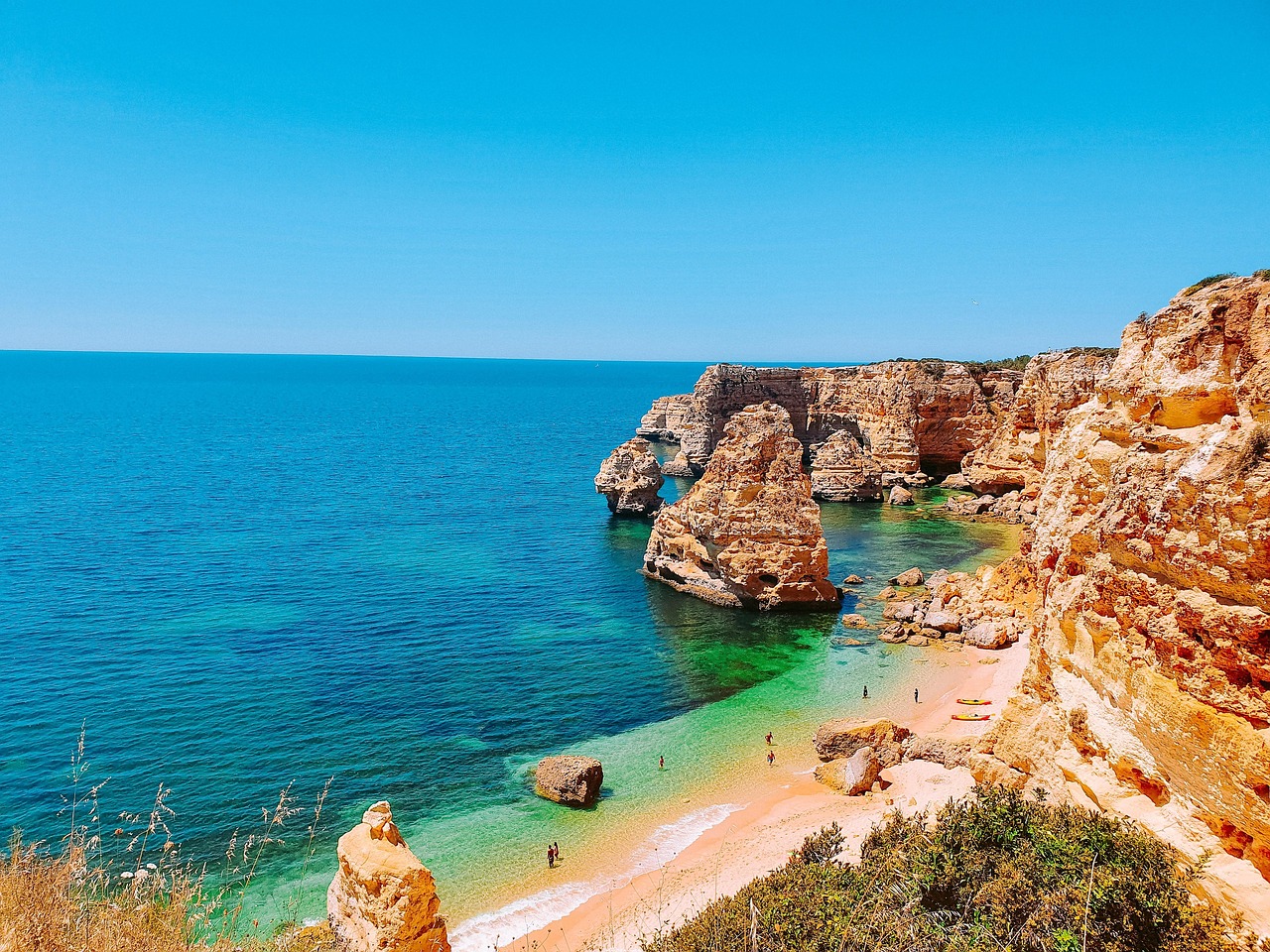 Scenic picture of beach surrounded by beautiful rock structures.